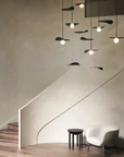 A room with a white chair and a KDLN Flow Ceiling Installation lamp.