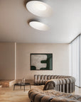 Modern living room with a sofa, coffee table, and abstract artwork on the wall.