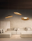 Modern living room with a beige sectional sofa, pendant lights, and a textured wall.