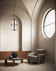 Modern interior with a round window, armchair, and coffee table.