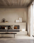 Modern living room with a gray sofa, coffee table, and decorative items.