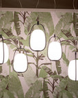 Modern pendant lights hanging against a leaf-patterned wall.