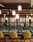 Modern restaurant interior with tables, chairs, and large windows.