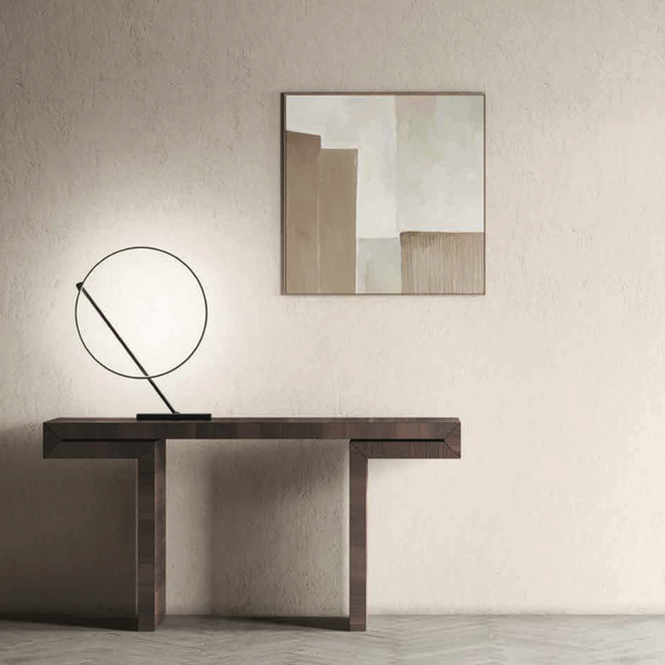 A KDLN Poise Table Lamp emits a circle of light, illuminating a painting on the wall.