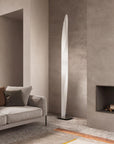 Modern living room with a tall floor lamp, sofa, and fireplace.