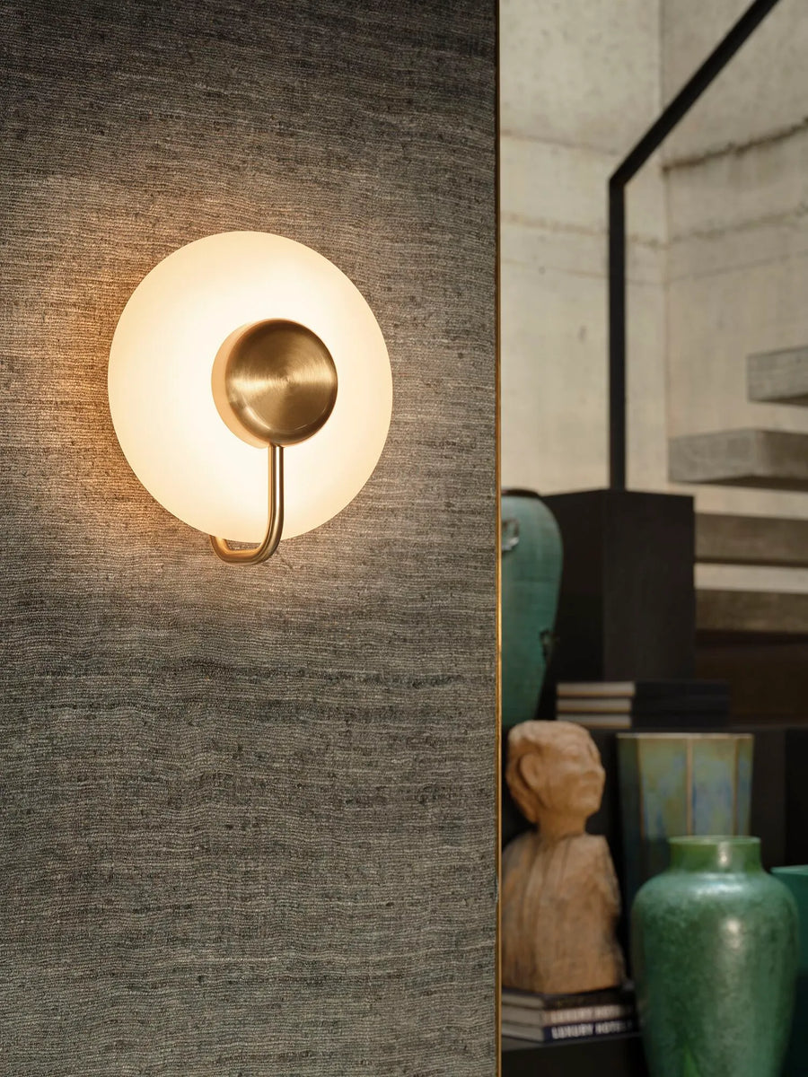 KDLN Tratto Wall in brass finish on a fabric panelled wall near a staircase in a modern home