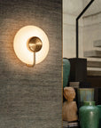 KDLN Tratto Wall in brass finish on a fabric panelled wall near a staircase in a modern home
