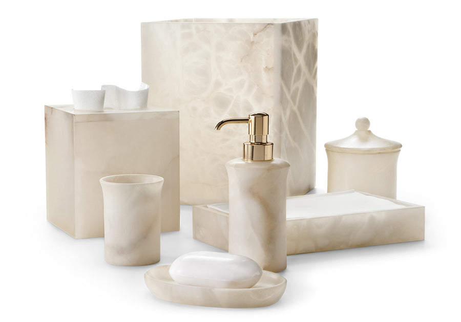 Beige marble bathroom accessories from Labrazel including a soap dispenser, soap dish, and containers on a white background.