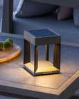 Modern outdoor solar lamp on a wooden table with a blurred background by Les Jardins available at Spacio retail stores in Mumbai & Kolkata.  