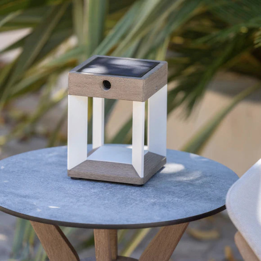 Solar-powered outdoor lamp on a table with plants in the back ground by Les Jardins available at Spacio retail stores in Mumbai & Kolkata.  