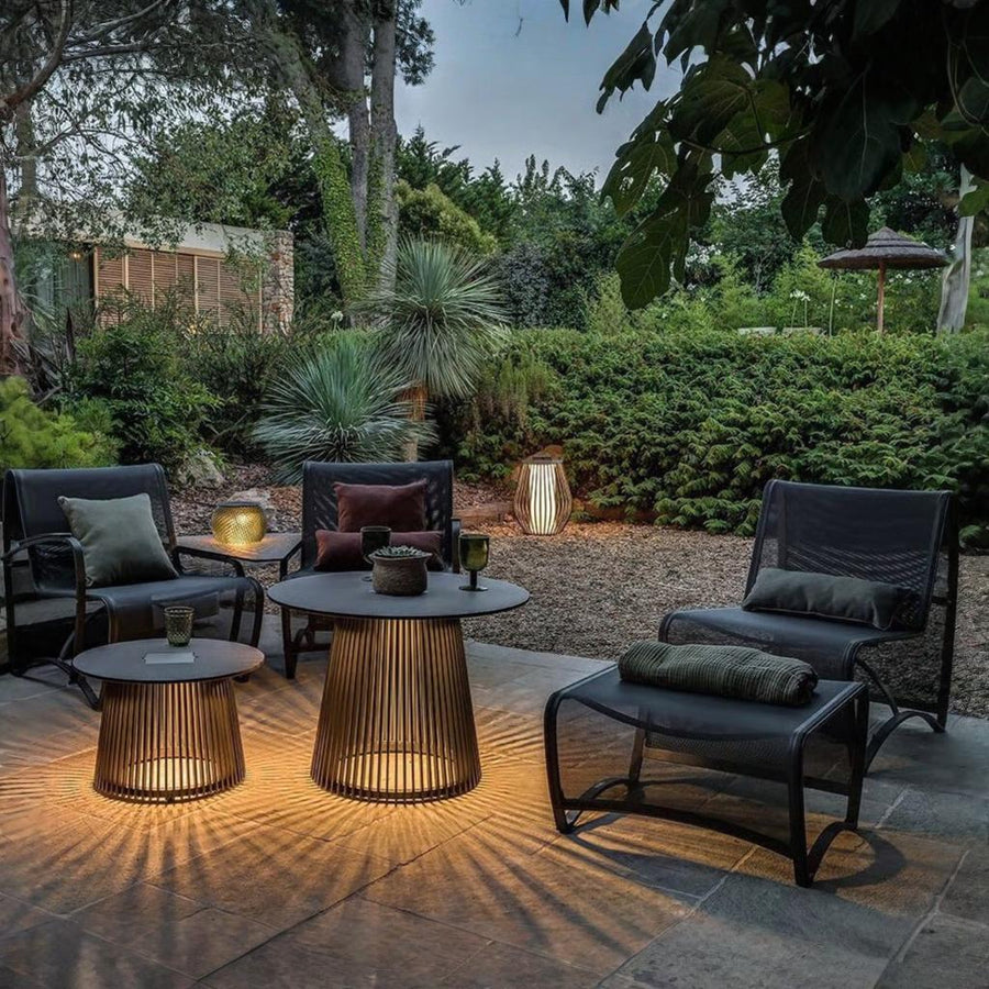Outdoor patio setting with chairs, tables, and decorative solar lights in a garden from Les Jardins available at Spacio retail stores in Mumbai & Kolkata. 