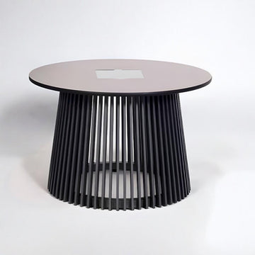 Modern round table with a black ribbed base and pinkish top on a white background with solar lighting from Les Jardins available at Spacio retail stores in Mumbai & Kolkata. 
