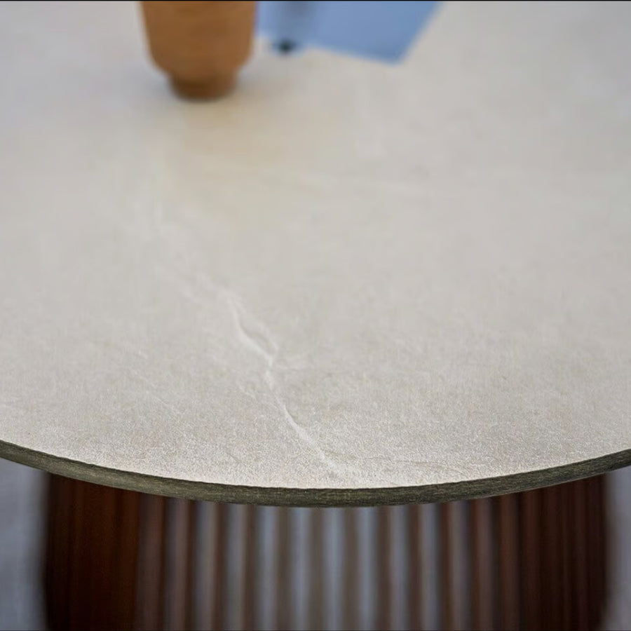 Round wooden table with a light-colored top and dark brown legs.