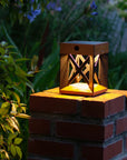 Wooden solar table lamp on a brick platform in a garden setting