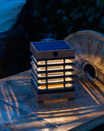 Solar lantern on a wooden surface with a blurred natural background
