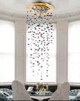 Decorative hanging crystal chandelier in a room with white walls and large windows.