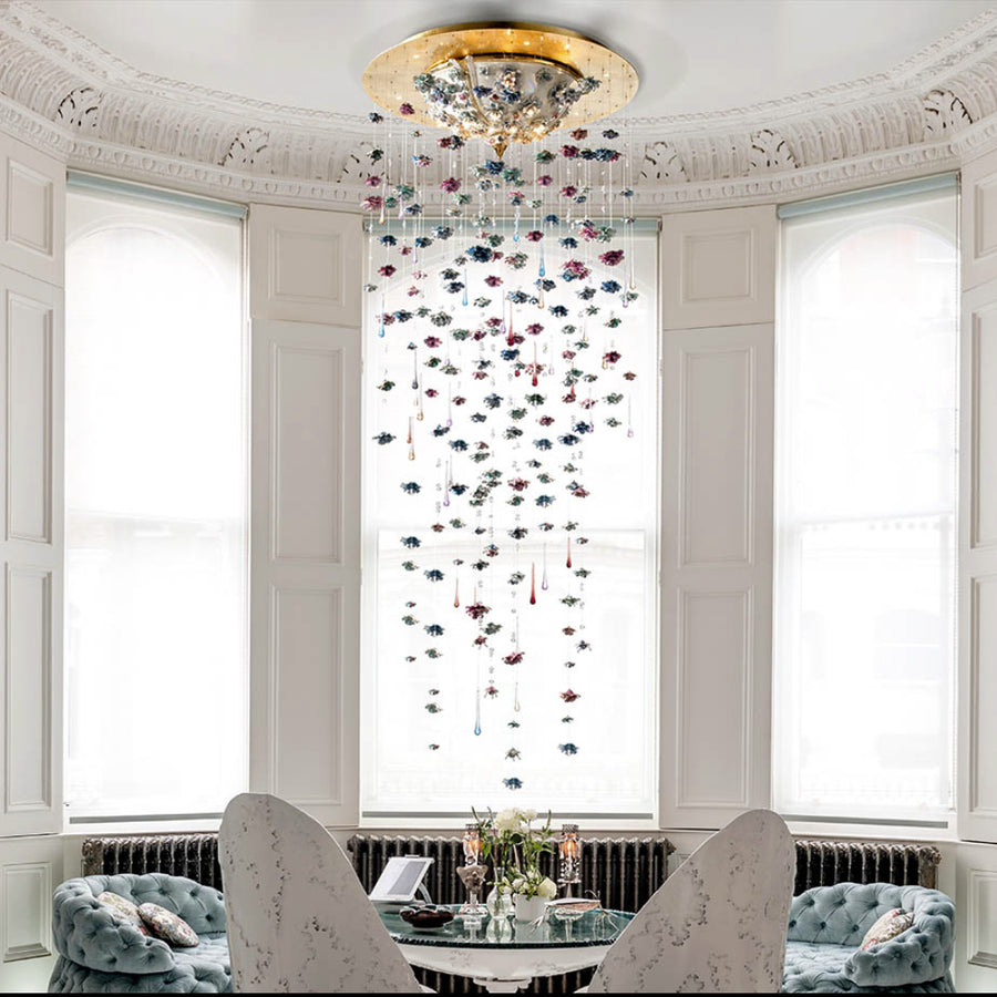 Decorative hanging crystal chandelier in a room with white walls and large windows.