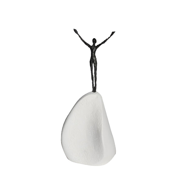 Bronze business motivational sculpture of a figure on a white rock-like base against a white background