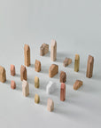 A group of ML Mini Houses Collection Kit 02 (3pc set) wooden blocks arranged on a white surface, resembling childhood objects, made by Madlab.