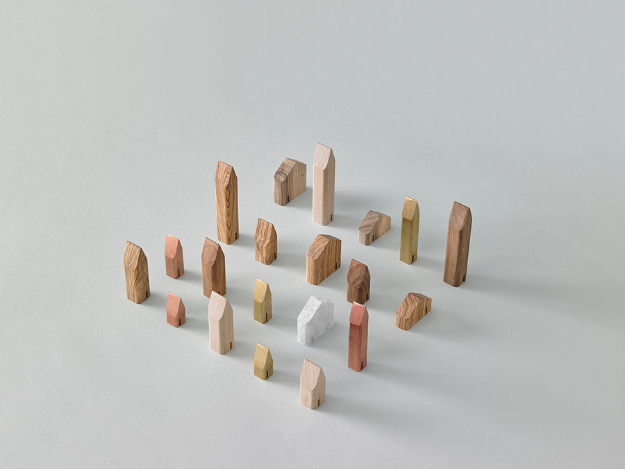 A group of ML Mini Houses Collection Kit 02 (3pc set) wooden blocks arranged on a white surface, resembling childhood objects, made by Madlab.