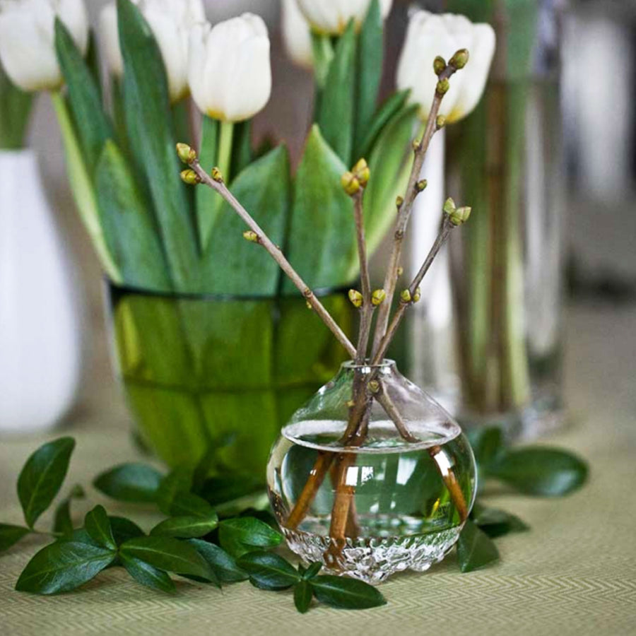 Maleras Crystal Into The Woods Vase with flowers on a sage green surface in modern interiors available at Spacio India from Decor Accessories Collection of Vases.