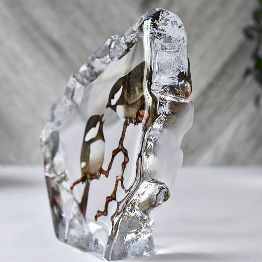 Side view of Maleras Crystal Sculpture Marsh Tits placed on a white table with marble background, available at Spacio India from the Sculptures and Art Objects Collection