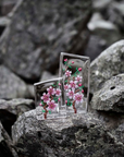 Distant look of Maleras Crystal Sculpture Cherry Blossom Small with other Large sculpture on a Grey stones outdoor back ground available at Spacio India from the Sculptures and Art Objects Collection.