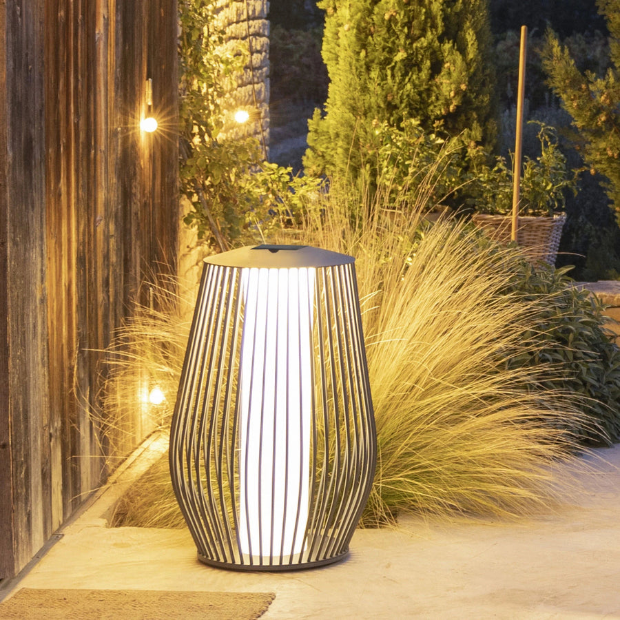 Decorative outdoor solar lamp on a patio with plants and wooden wall in the background by Les Jardins available at Spacio retail stores in Mumbai & Kolkata. 