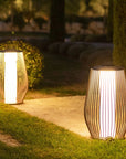 Two illuminated outdoor solar lamps on a grassy area with a blurred natural background by Les Jardins available at Spacio retail stores in Mumbai & Kolkata. 