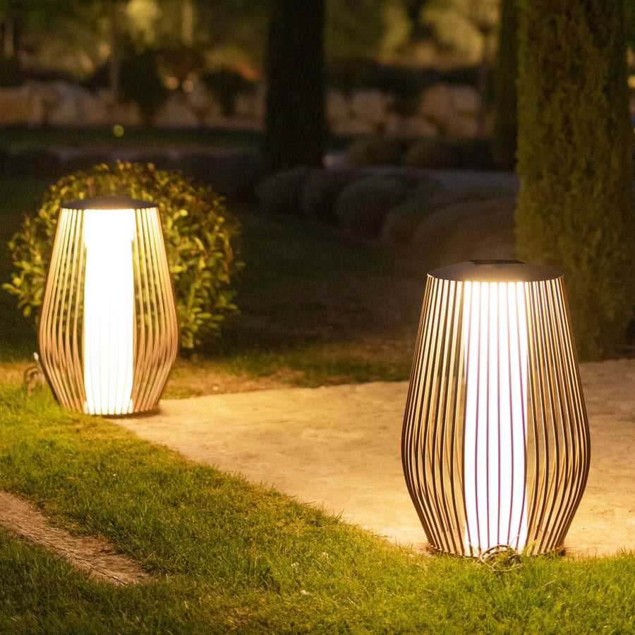 Two illuminated outdoor solar lamps on a grassy area with a blurred natural background by Les Jardins available at Spacio retail stores in Mumbai & Kolkata. 