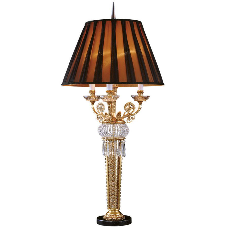 Decorative table lamp with gold base, crystal details, and black striped shade on a white background