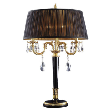 Decorative table lamp with black shade and gold accents on a white background