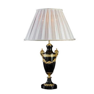 Decorative table lamp with a black base and gold accents on a white background