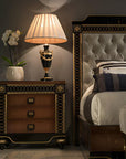 Decorative nightstand with lamp and bed in a bedroom setting
