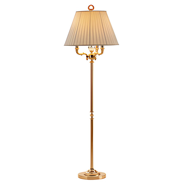 Gold floor lamp with a pleated beige shade on a white background