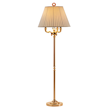 Gold floor lamp with a pleated beige shade on a white background