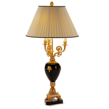 Decorative table lamp with gold and black base on a white background