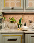 Decorative elements on a kitchen counter with cabinets and backsplash.