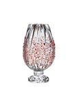 Decorative crystal vase with red speckles on a white background