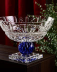 Decorative crystal bowl with blue base on a wooden surface