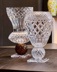 Two crystal vases on a wooden surface with a blurred background