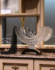 Decorative crystal bowl on a marble surface with a mirror in the background
