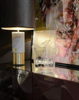 Decorative table with a lamp, crystal vase, and abstract painting