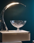 Modern table lamp with curved glass arm table lamp and crystal bowl on a dark background