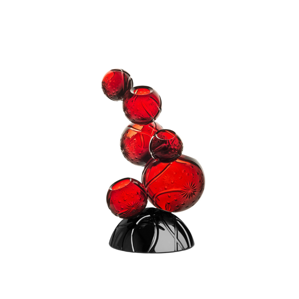 Red crystal sculpture on a black base against a white background
