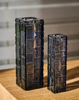 Two decorative crystal vases with a geometric pattern on a wooden surface.