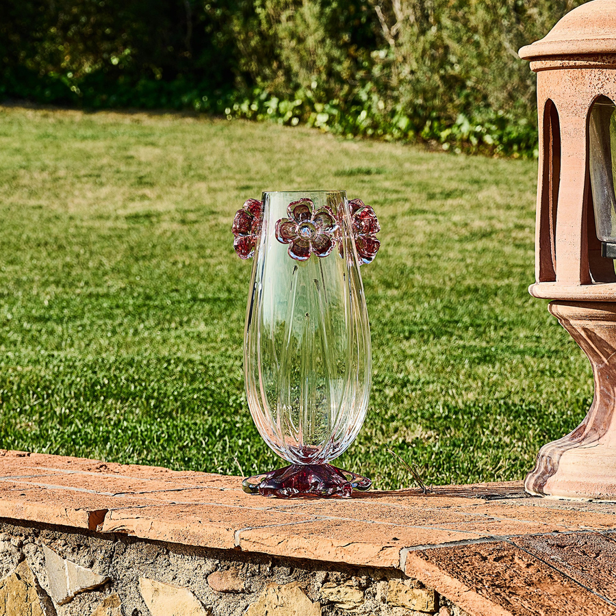 Mario Cioni Cistus Tall Crystal Vase with red flowers, handcrafted in Italy, featuring a cylindrical design and intricate floral details for luxury interiors. Set in a garden outdoor