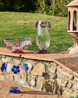 A pair of Handcrafted Mario Cioni Cistus Crystal Vases placed outdoors, featuring intricate red flower accents and elegant detailing for luxury decor.