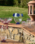 Handcrafted Mario Cioni Cistus crystal collection placed outdoors, featuring intricate red flower accents and elegant detailing for luxury decor.