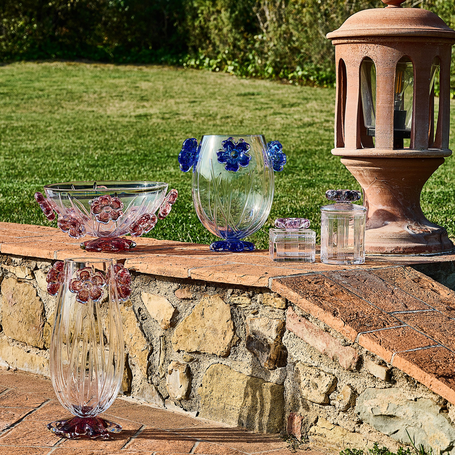 Handcrafted Mario Cioni Cistus crystal collection placed outdoors, featuring intricate red flower accents and elegant detailing for luxury decor.